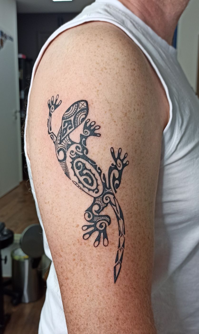 Gecko im Tribal-Stil am Oberarm